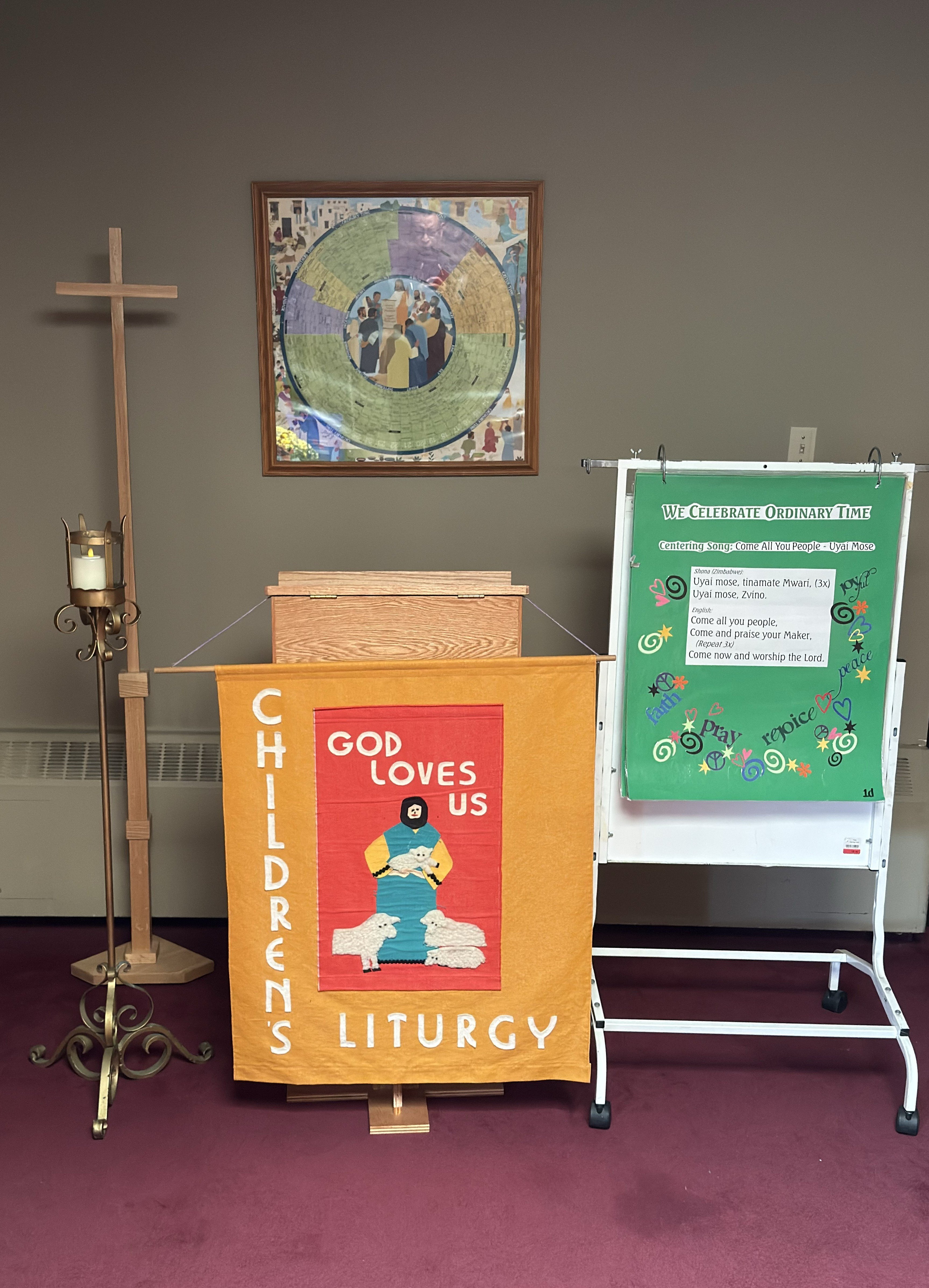 Children's Liturgy set up with an ambo, cross, candle and an easel with songs