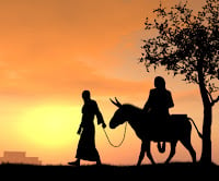 An image of Joseph leading a donkey. Mary is riding the donkey