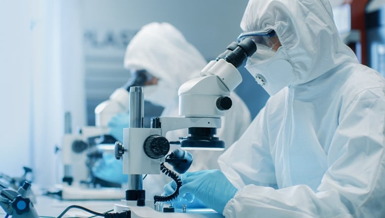 A couple of scientists looking through their microscopes