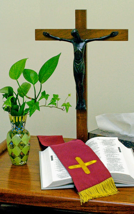 An image of a purple stole on a bible, near a cross
