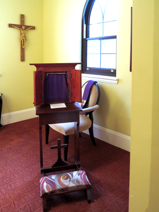 Confession room with a cross and a kneeler