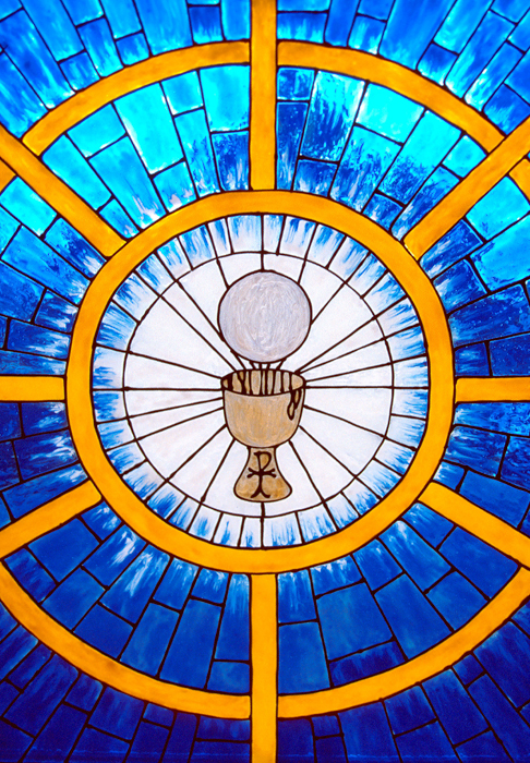 An image of a stain glass window with a consecrated Host and Chalice in the middle