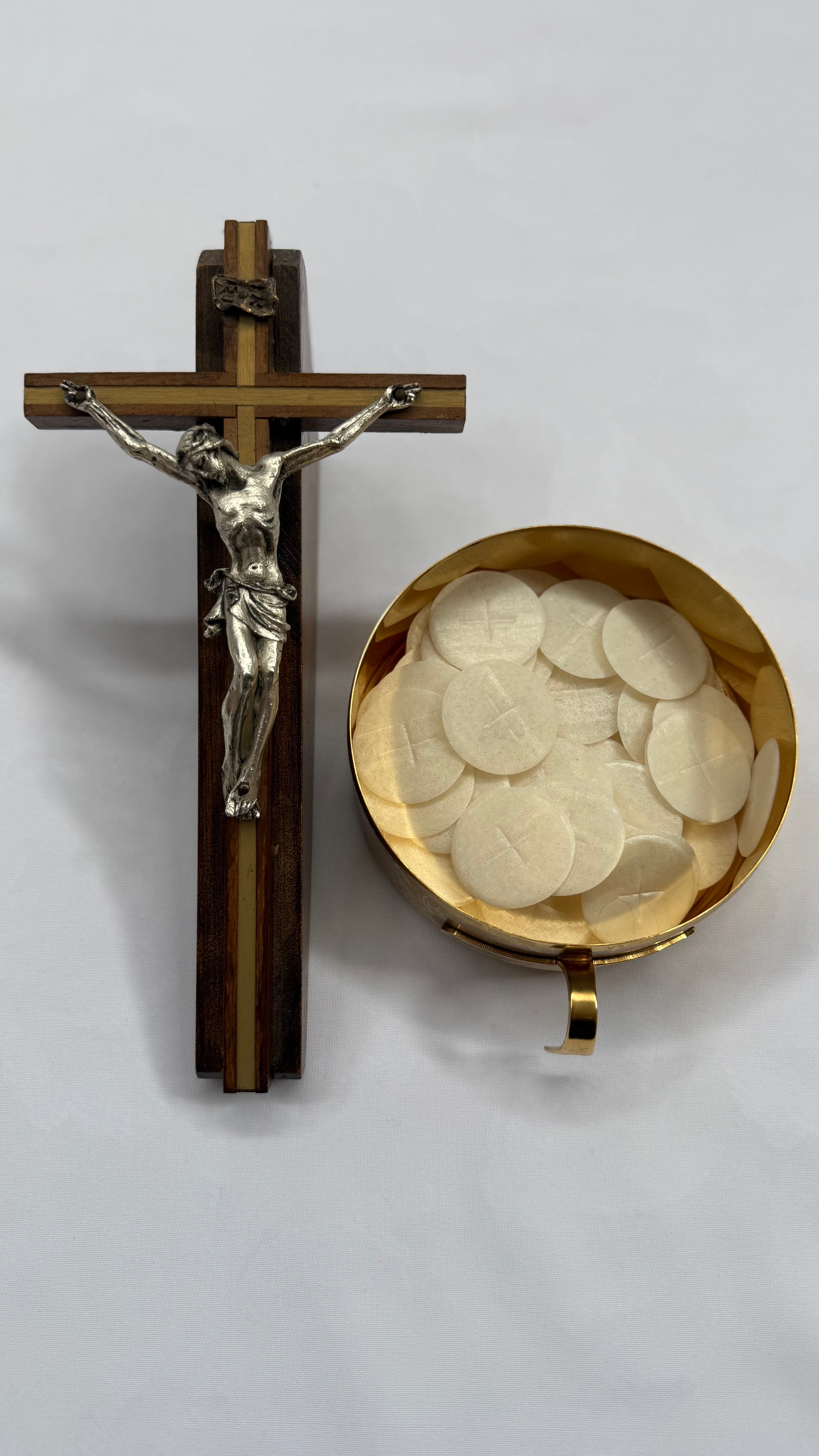 A crucifix next to a ciborium full of hosts