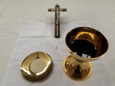 A chalice, a paten with bread and a crucifix