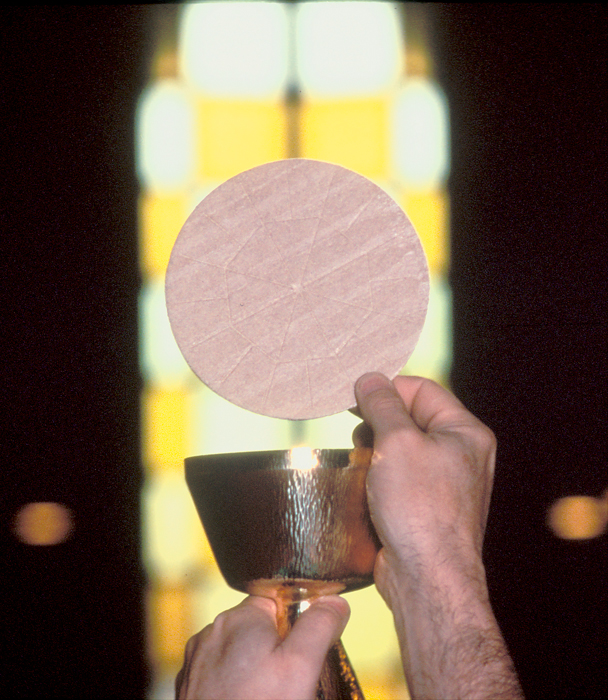 A photo of Final Elevation of the consecrated Host and Chalice as the congregation sings Amen.