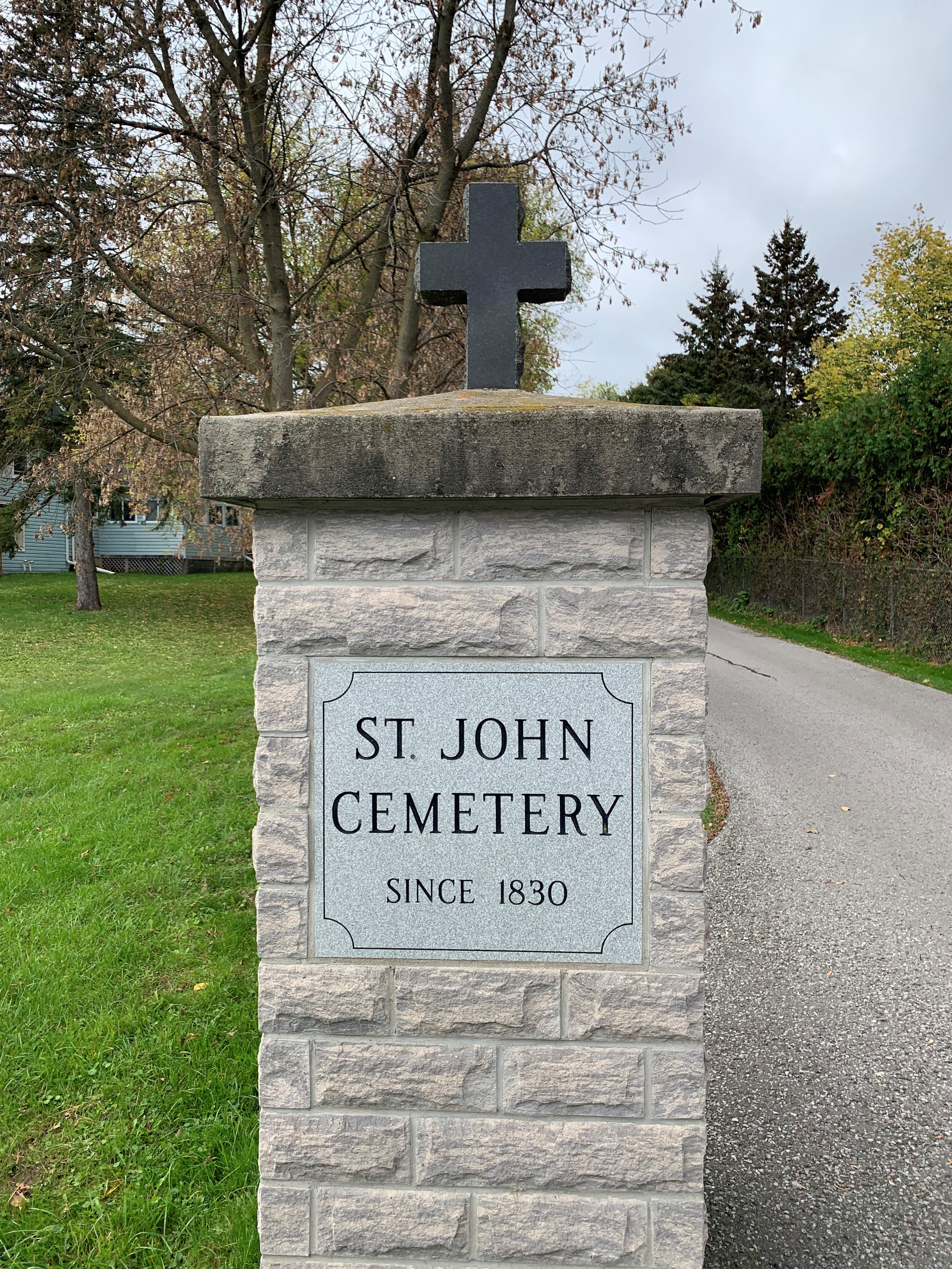 A picture of one a column inscribed with the Cemetery name. The inscription reads: St. John Cemetery, since 1830.